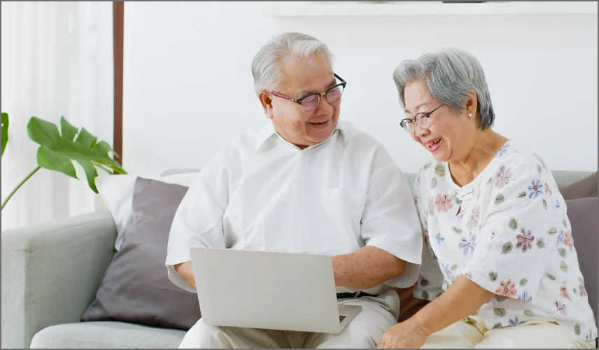 happy senior couple using laptop All Utilities service golden valley senior living